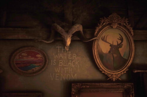 The interior of the cabin at Bayall Edge. "The Water is Black with Venom" is painted onto the wall under a ram's skull.