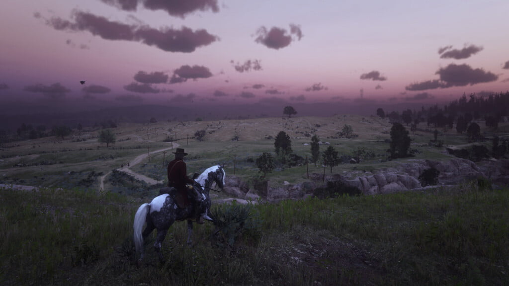 John Marston on a dapple gray pinto Missouri Fox Trotter. They stand on a cliff overlooking West Elizabeth. The sun has just set and the sky is purple-pink.