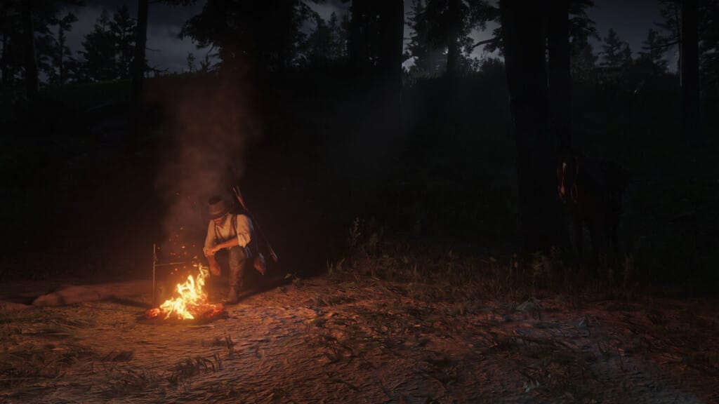 Arthur Morgan squatting by his campfire at night.