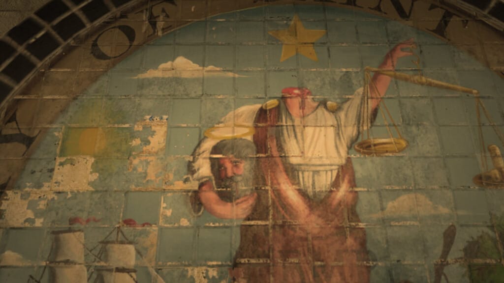 Detail of the city seal for Saint Denis, as seen painted on the police station floor. Saint Denis carries his own head in one hand and a pair of scales in the other.