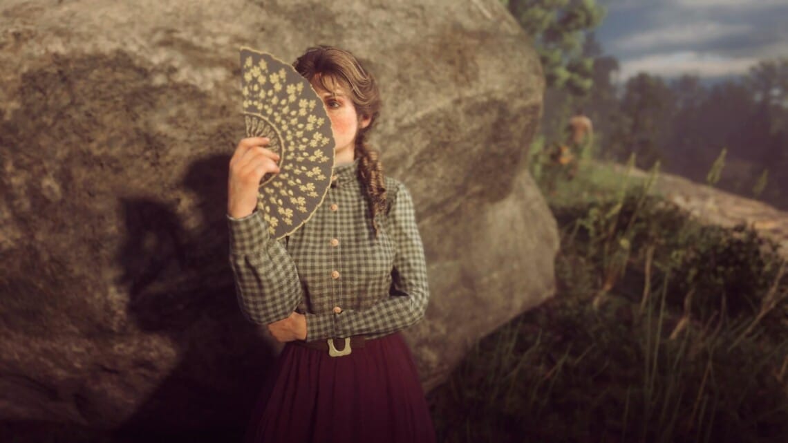 Mary-Beth Gaskill using a hand fan at Horseshoe Overlook. The fan is hiding half her face from view.