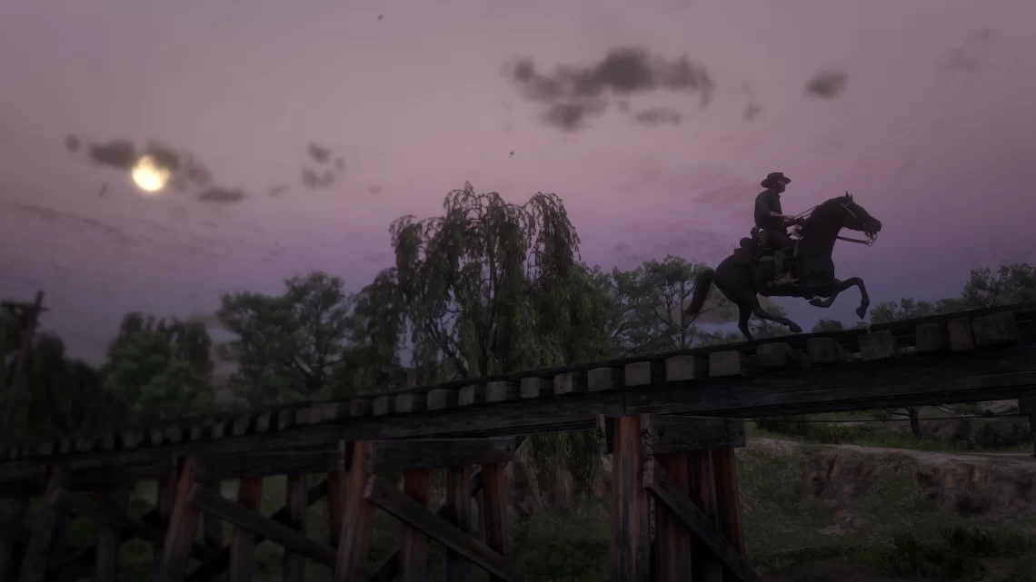 John Marston galloping over a railroad bridge under the rising moon.